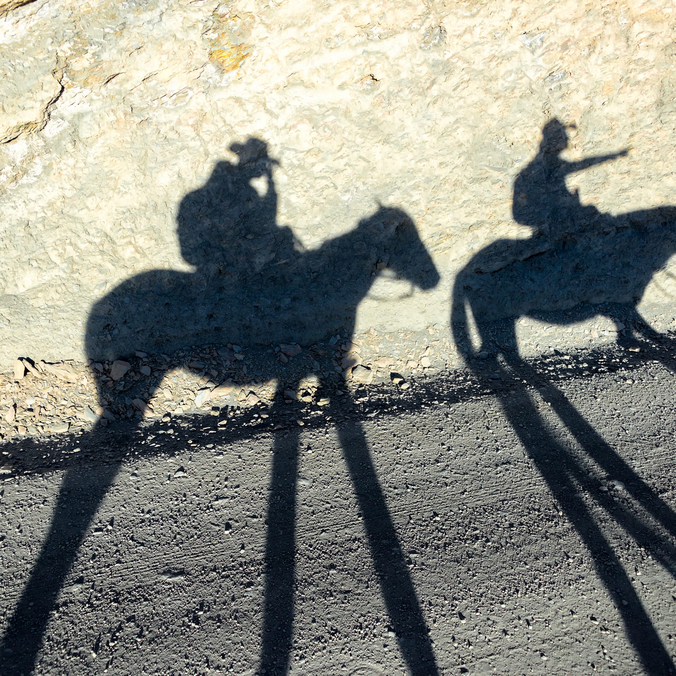 Late afternoon shadows of two horses and two riders near Tupiza, Bolivia